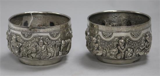 Two Burmese white metal Thabeik bowls of traditional form, embossed with deities and figures,